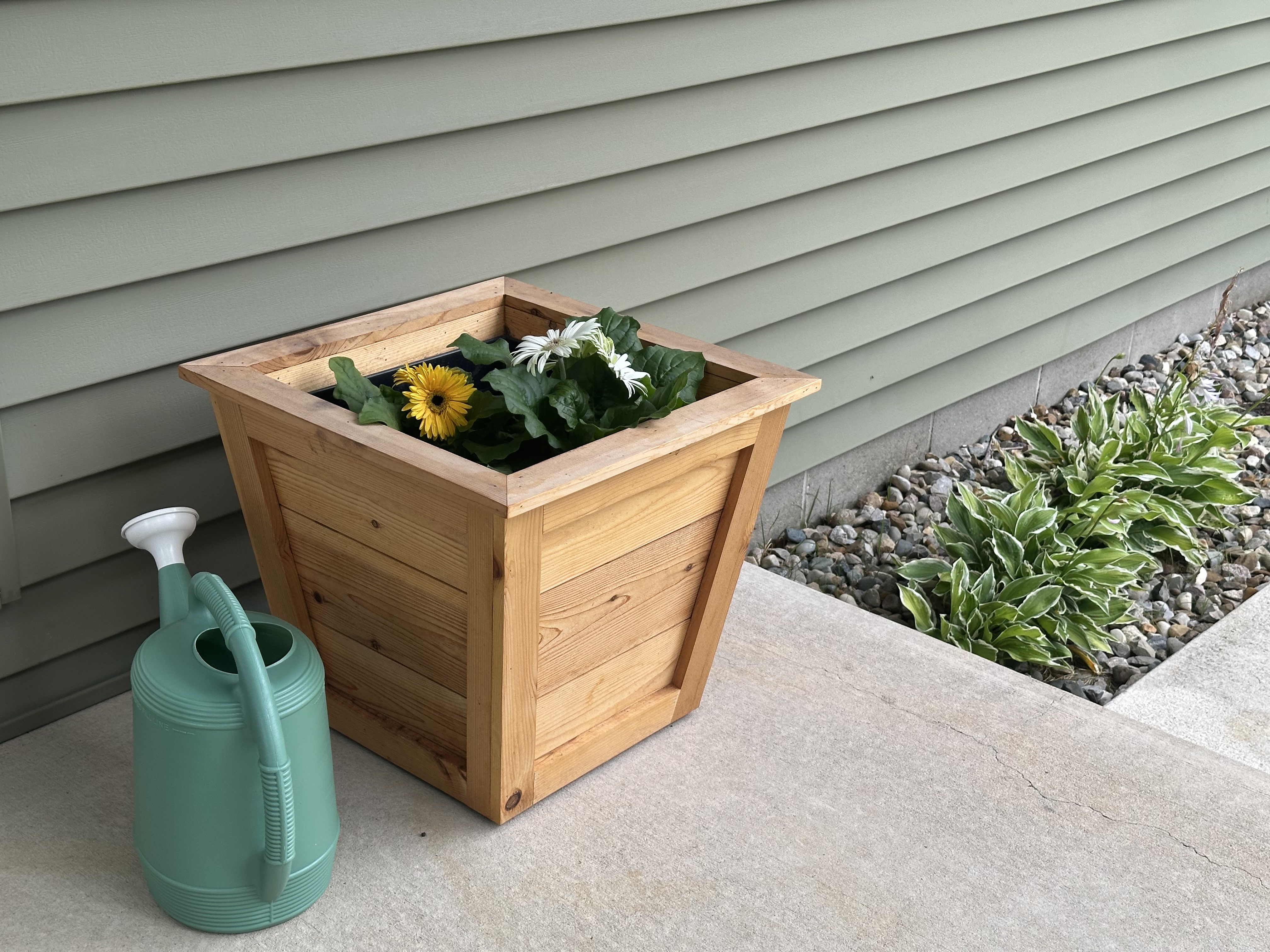 Cedar planter with flowers near front entry walkway